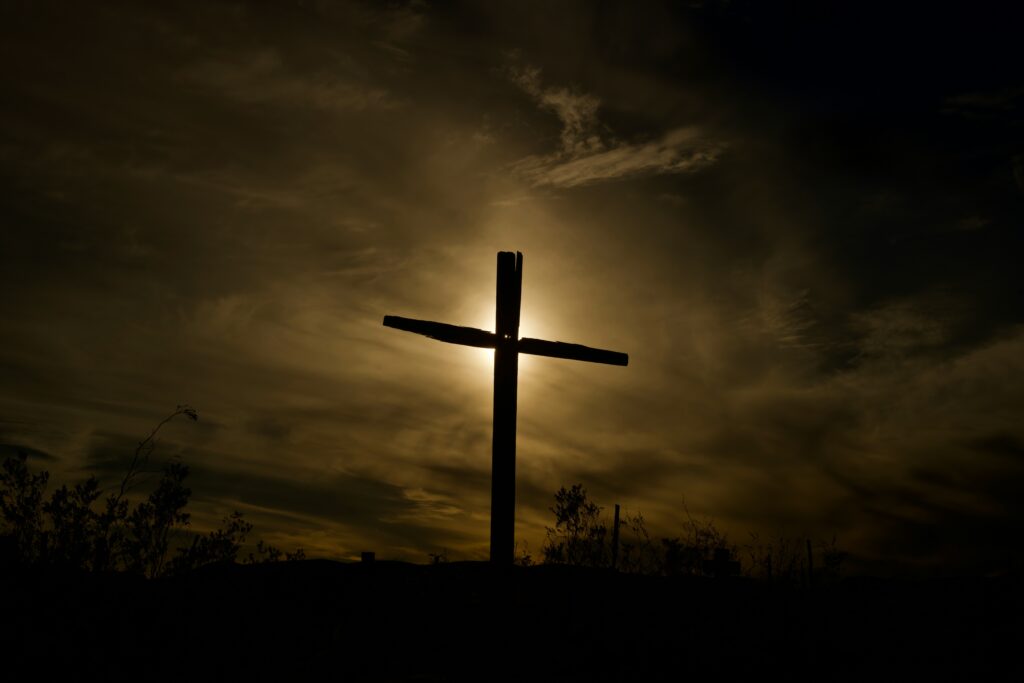 Dark, moody sky with a silhouette of a cross, symbolizing faith in times of persecution.