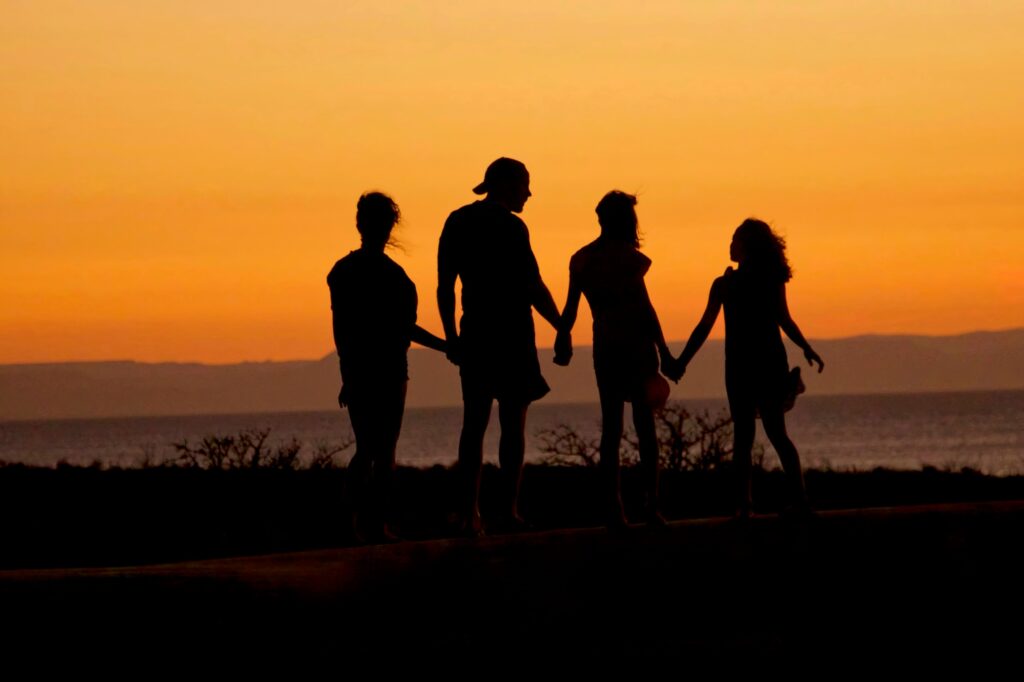 A family holding hands in the sunset.