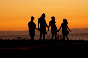 A family holding hands in the sunset.